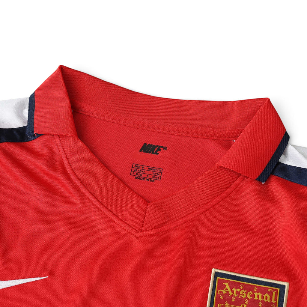 Elite Retro Kits Arsenal 2001/02 home shirt featuring red fabric, white sleeves, and Nike branding at the collar.
