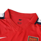Elite Retro Kits Arsenal 2001/02 home shirt featuring red fabric, white sleeves, and Nike branding at the collar.