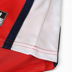 Close-up of Elite Retro Kits Arsenal 1998/99 home shirt sleeve featuring red fabric, white trim, and navy accents.