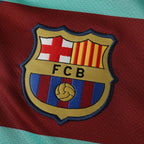 Elite Retro Kits Barcelona 2010/11 away shirt featuring a detailed embroidered FCB club crest on a maroon background.