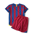 Elite Retro Kits Barcelona 2005/06 kids home kit featuring blue and maroon stripes with matching red shorts.