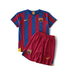 Elite Retro Kits Barcelona 2005/06 kids home kit with blue and maroon striped jersey and matching red shorts.