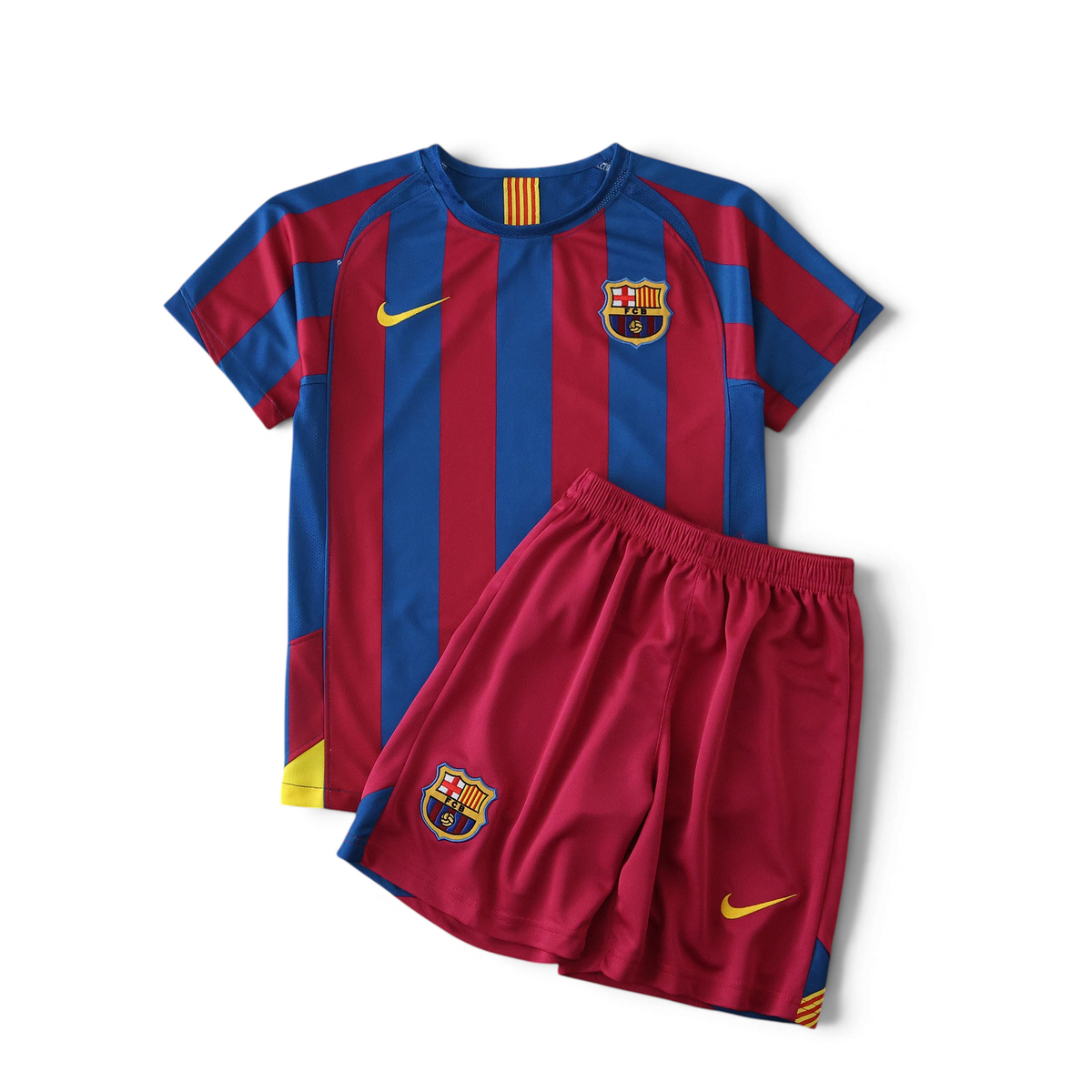 Elite Retro Kits Barcelona 2005/06 kids home kit with blue and maroon striped jersey and matching red shorts.