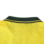 Elite Retro Kits Brazil 1992 home shirt featuring a yellow fabric with a subtle pattern and a dark green buttoned collar