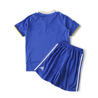 Elite Retro Kits Chelsea 2008/09 kids home football kit in blue with white and yellow trim on a green pitch background
