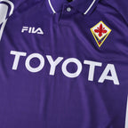 Elite Retro Kits Fiorentina 1999/00 home shirt in purple with white collar, Fila logo, and Toyota sponsor detail.