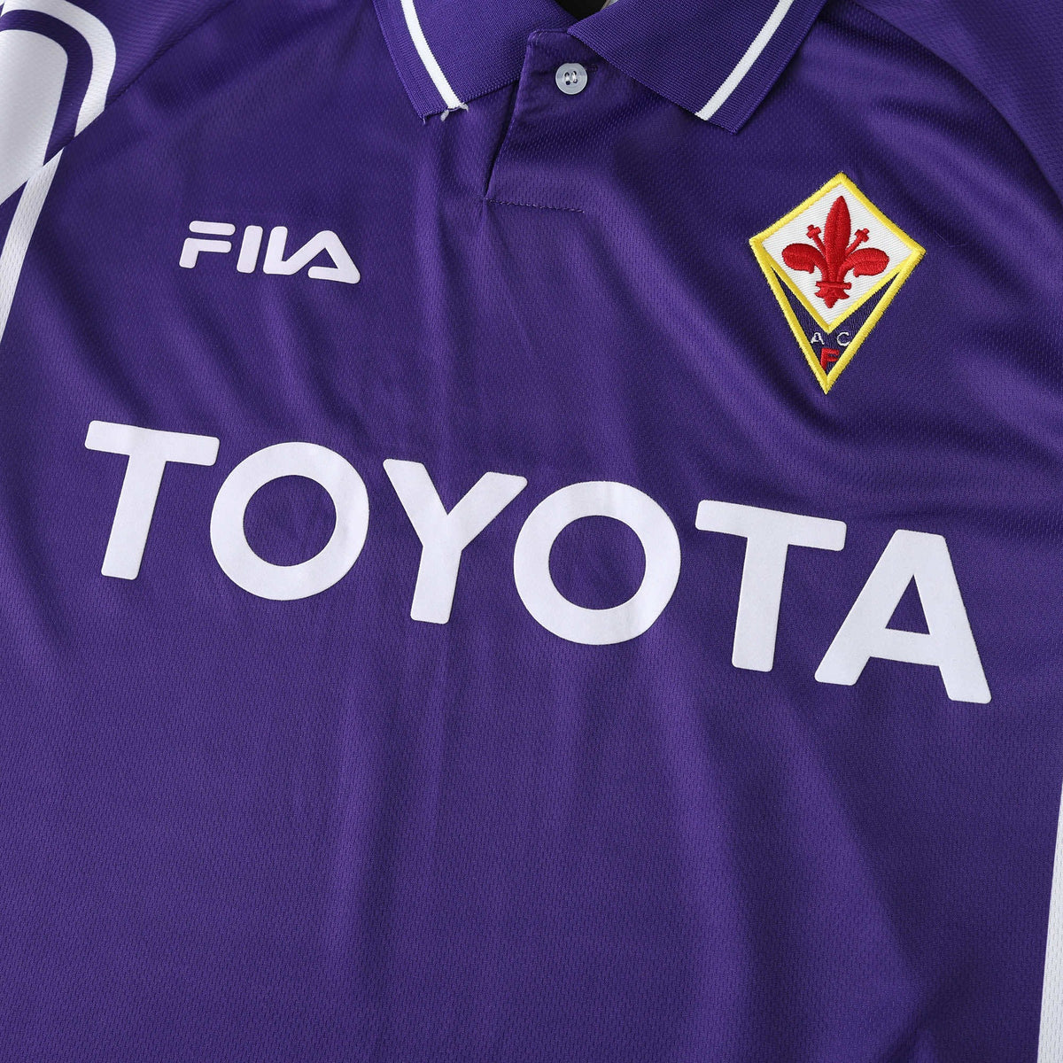 Elite Retro Kits Fiorentina 1999/00 home shirt in purple with white collar, Fila logo, and Toyota sponsor detail.