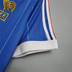 Elite Retro Kits France 1982 home football shirt featuring blue fabric, white pinstripes, and tricolour shoulder trim.