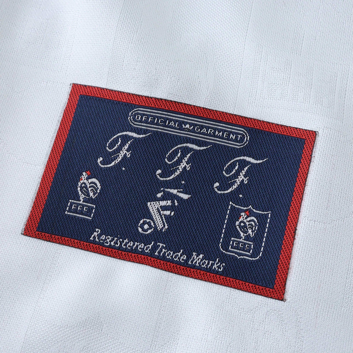 Elite Retro Kits France 1996 away shirt detail showing the official FFF woven brand patch on white fabric