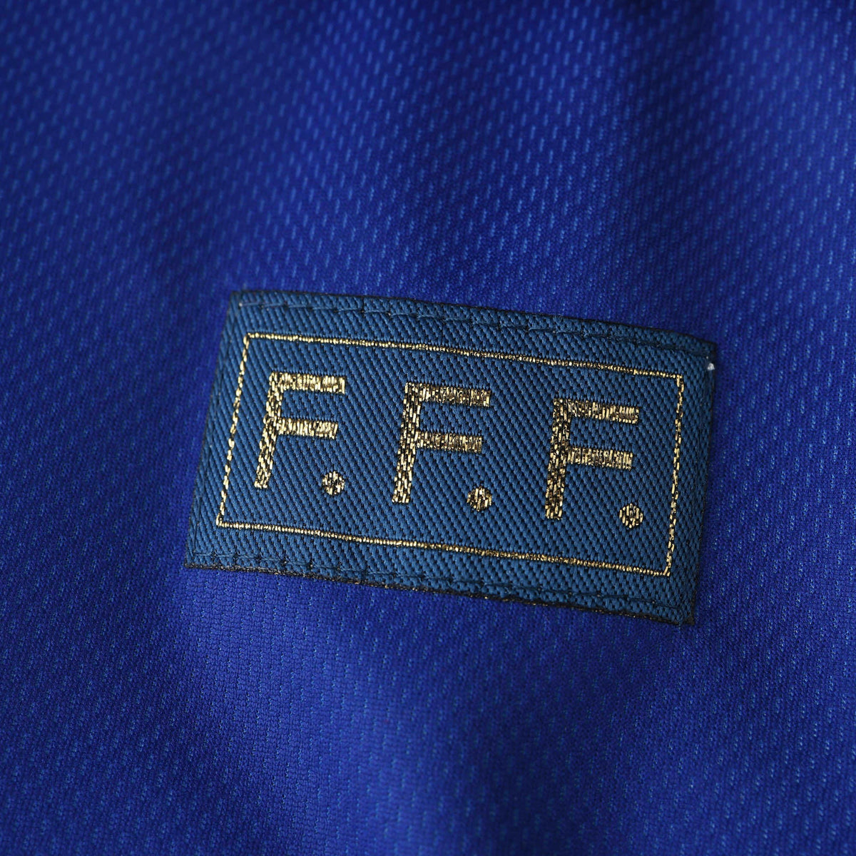 Elite Retro Kits France 1998 World Cup home shirt detail featuring the gold F.F.F. emblem on deep blue fabric