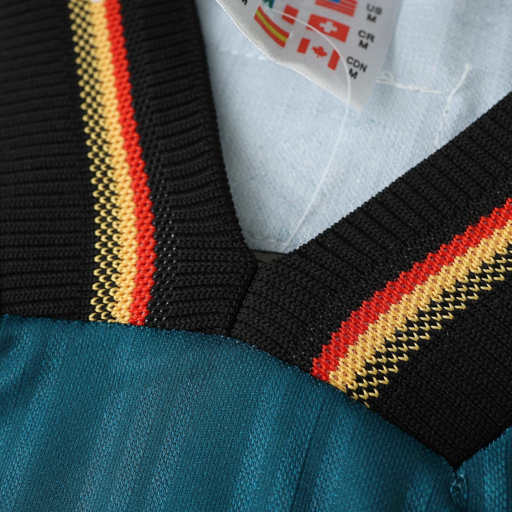 Elite Retro Kits Germany 1996 away shirt collar detail featuring green fabric with black, red, and yellow trim.