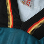 Elite Retro Kits Germany 1996 away shirt collar detail featuring green fabric with black, red, and yellow trim.