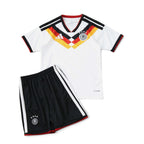Elite Retro Kits Germany 2026 kids home football kit featuring a white jersey with black, red, and gold chest graphic.