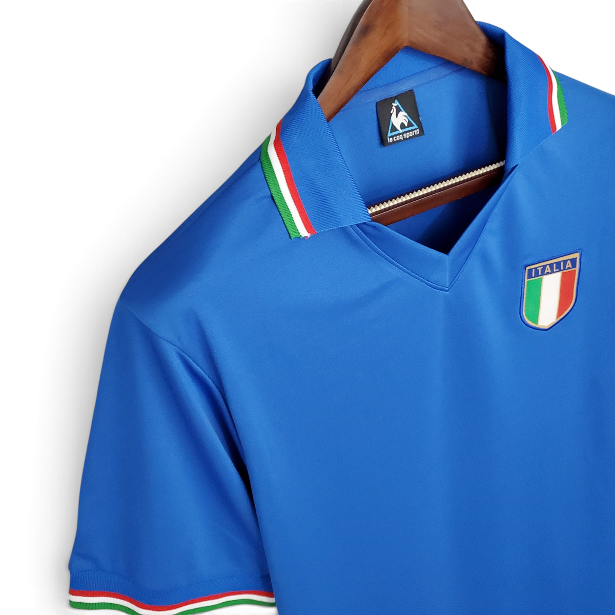 Elite Retro Kits Italy 1982 home football shirt in blue with tricolor collar and sleeve trim on a wooden hanger