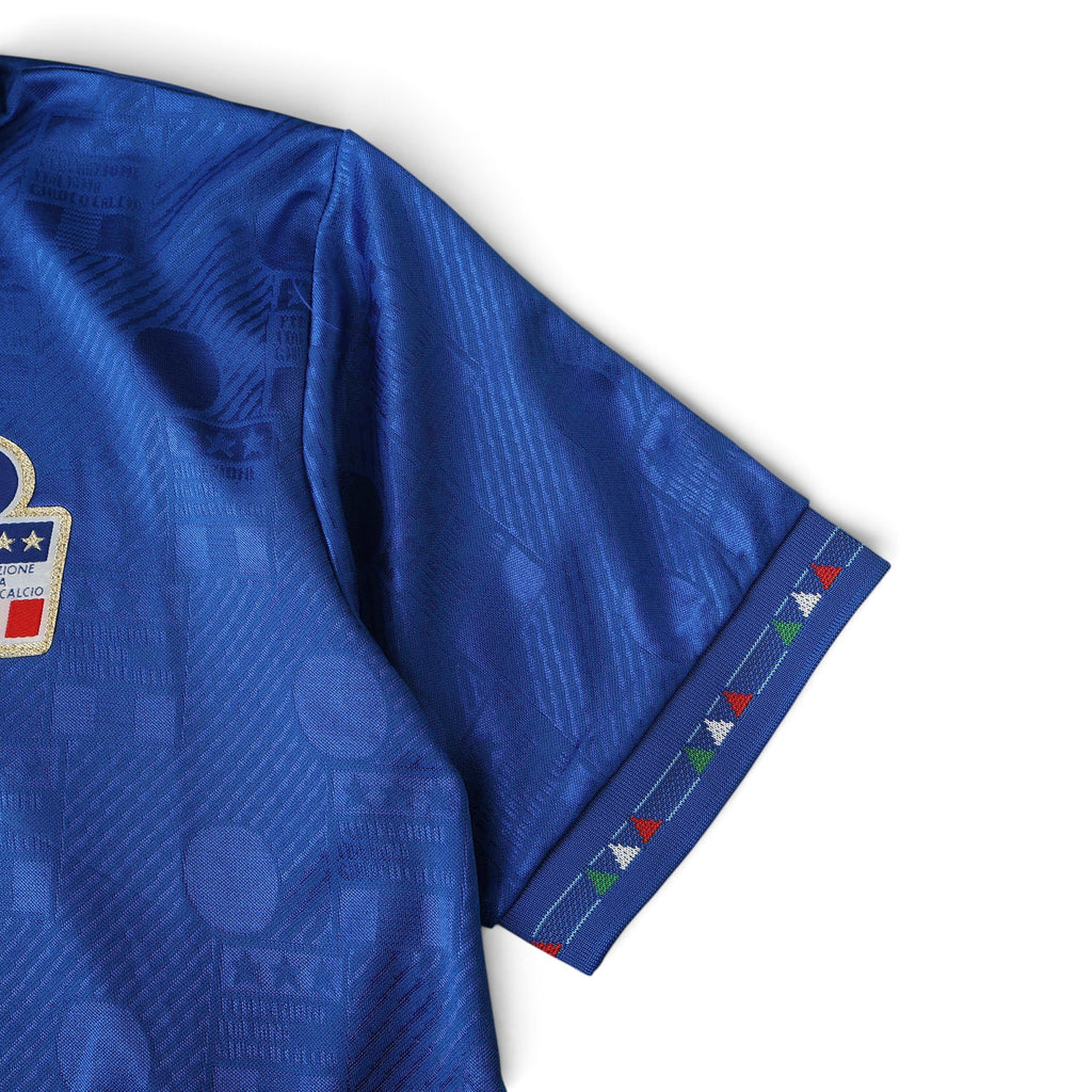 Elite Retro Kits Italy 1994 home football shirt in blue with subtle geometric pattern and tricolour sleeve trim.
