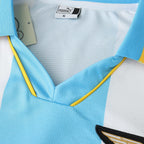 Elite Retro Kits Lazio 1999/00 home shirt featuring iconic celeste blue and white stripes with yellow trim detail.