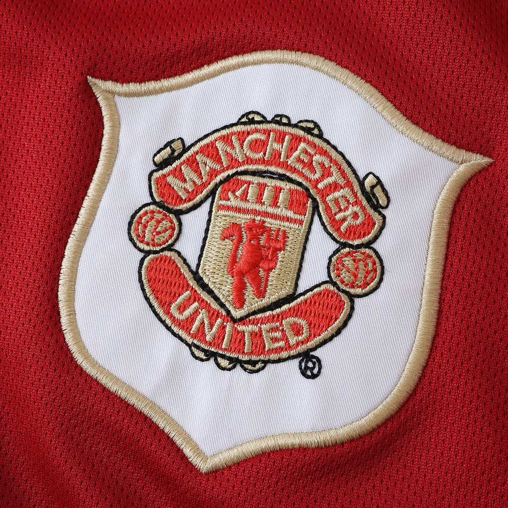 Elite Retro Kits Manchester United 2006/07 kids home kit featuring the embroidered club crest on red fabric