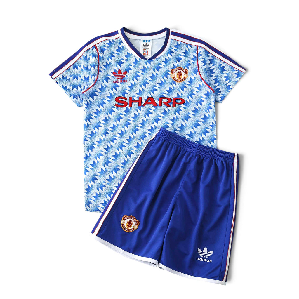 Elite Retro Kits Manchester United 1990-92 away kids kit featuring a blue and white graphic jersey and blue shorts.