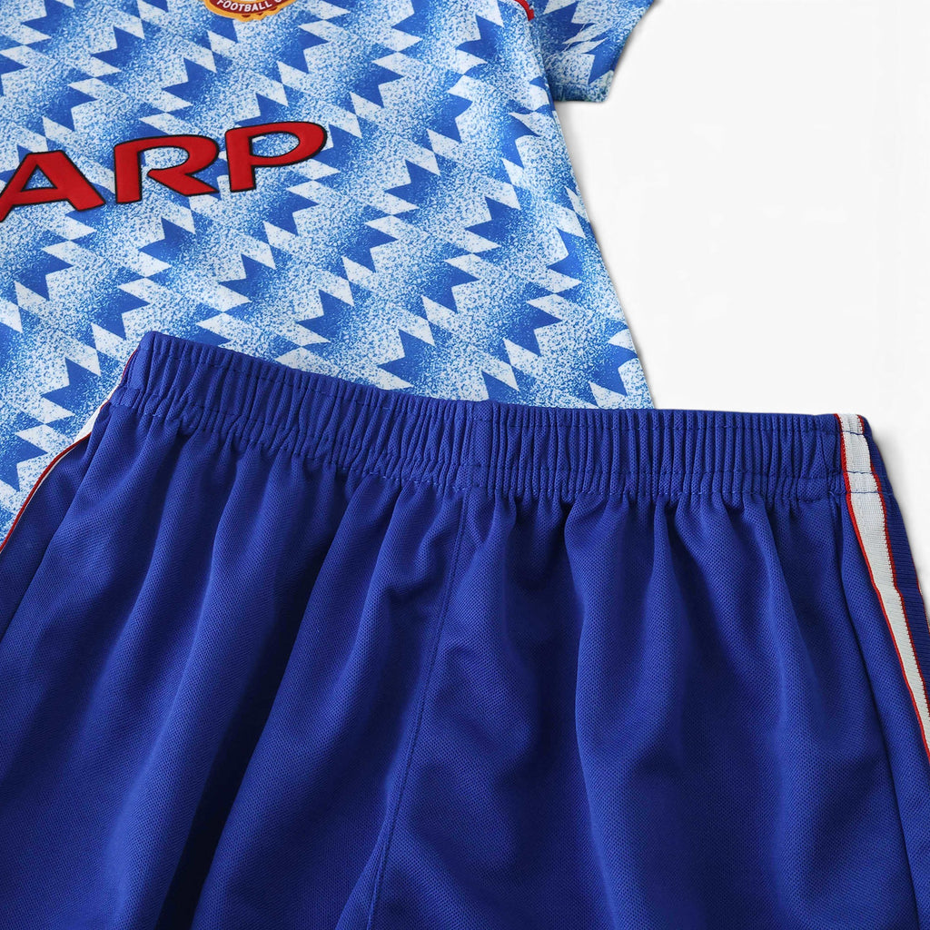 Elite Retro Kits Manchester United 1990/92 away kids kit featuring a blue and white patterned shirt and blue shorts.