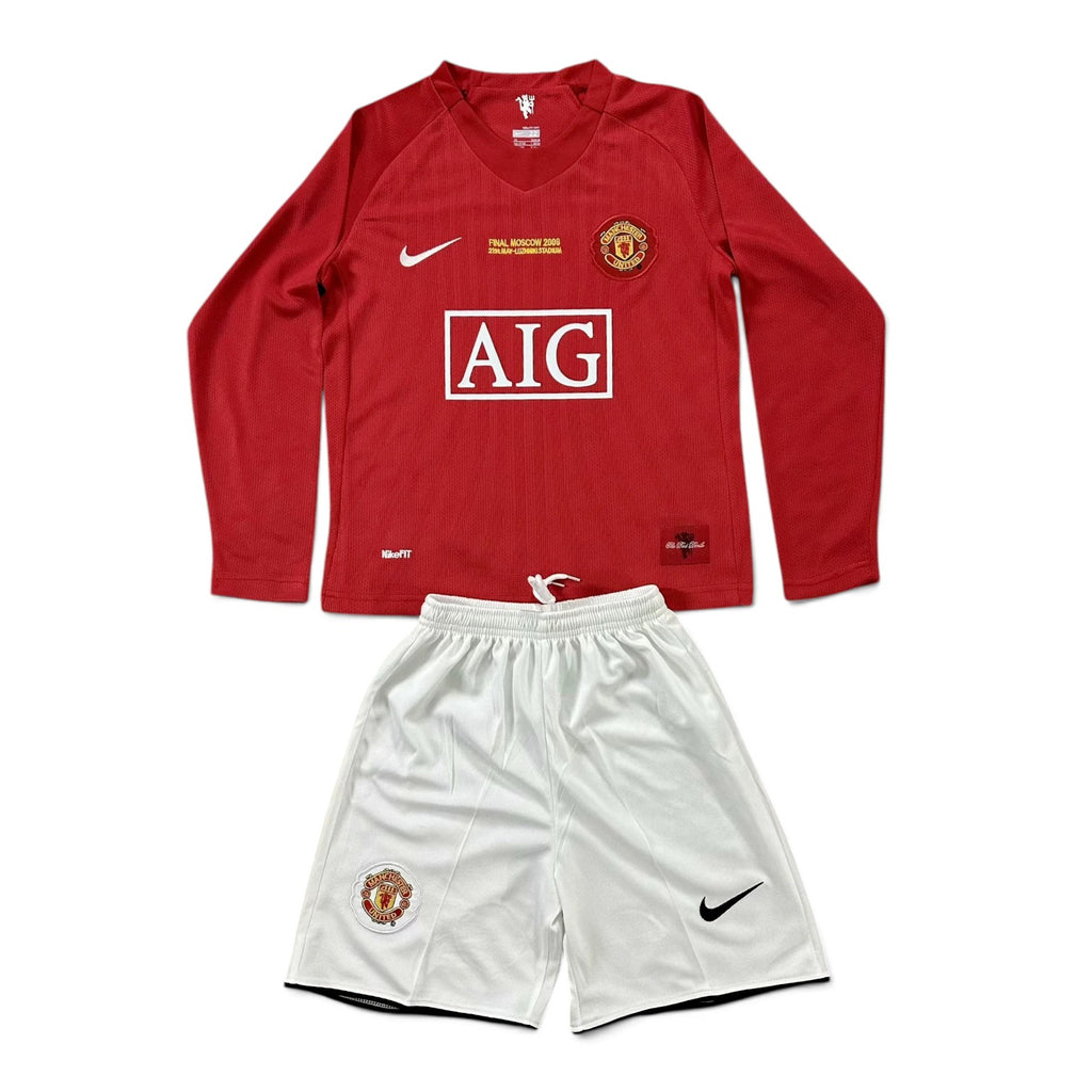 Elite Retro Kits Manchester United 2007/08 kids home kit featuring a red long-sleeve jersey and white shorts.