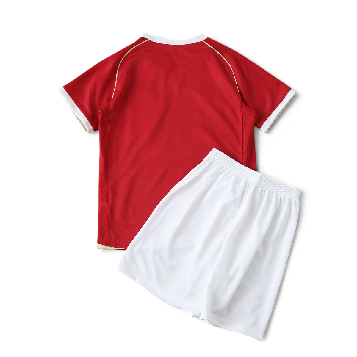 Elite Retro Kits Manchester United 2006/07 kids home kit featuring a red jersey and white shorts on a pitch background