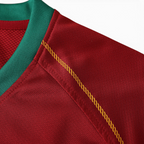 Elite Retro Kits Portugal 2006 home shirt detail showing red fabric, green ribbed collar, and gold shoulder stitching.