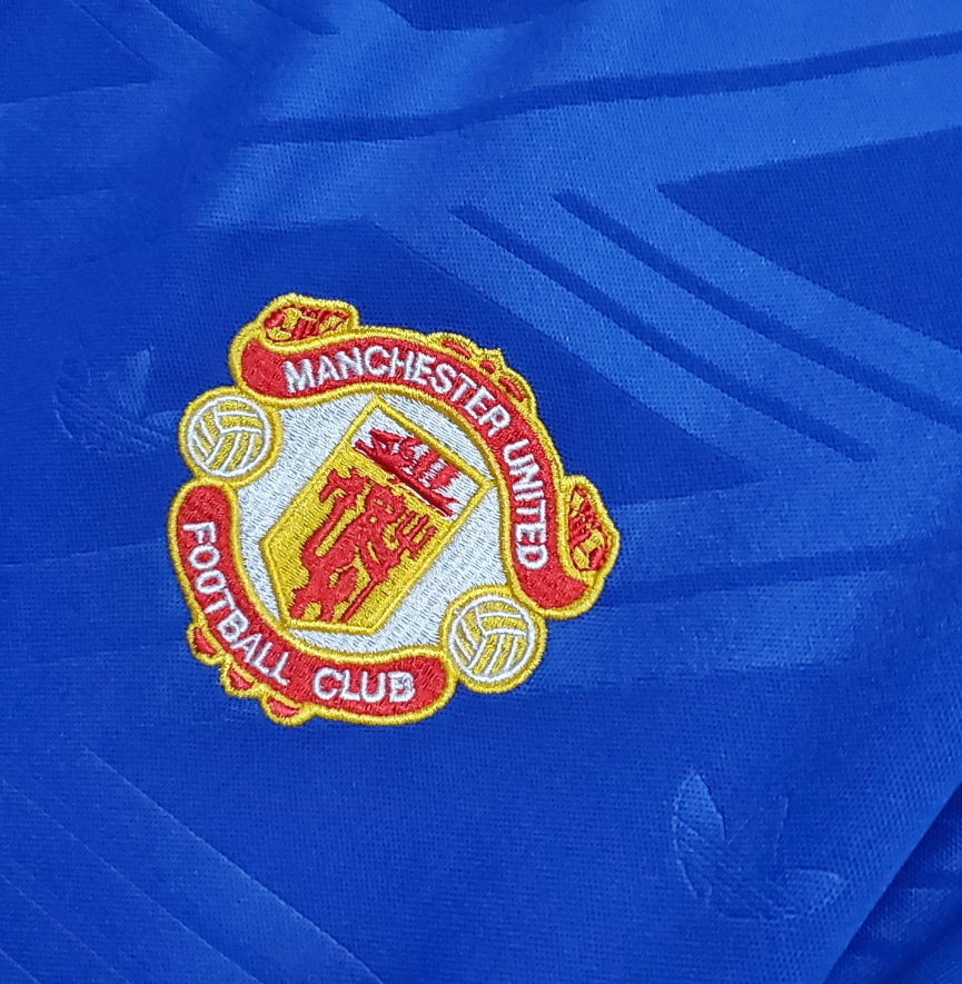 Stitched Manchester United Logo on the 1987 3rd shirt.