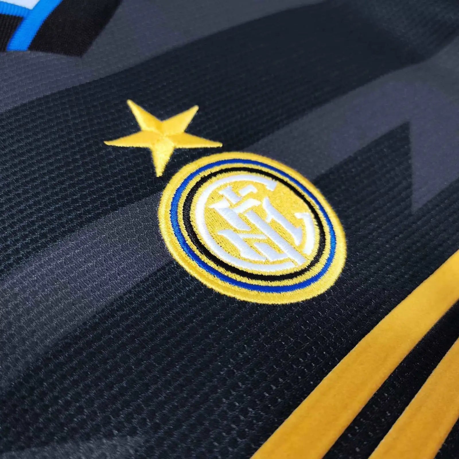 Close-up of a sports team logo on a dark background with yellow accents