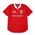 A red short-sleeve soccer jersey with a white V-neck collar, featuring the Manchester United crest, 'SHARP' sponsor logo, and 'UMBRO' text on the chest.