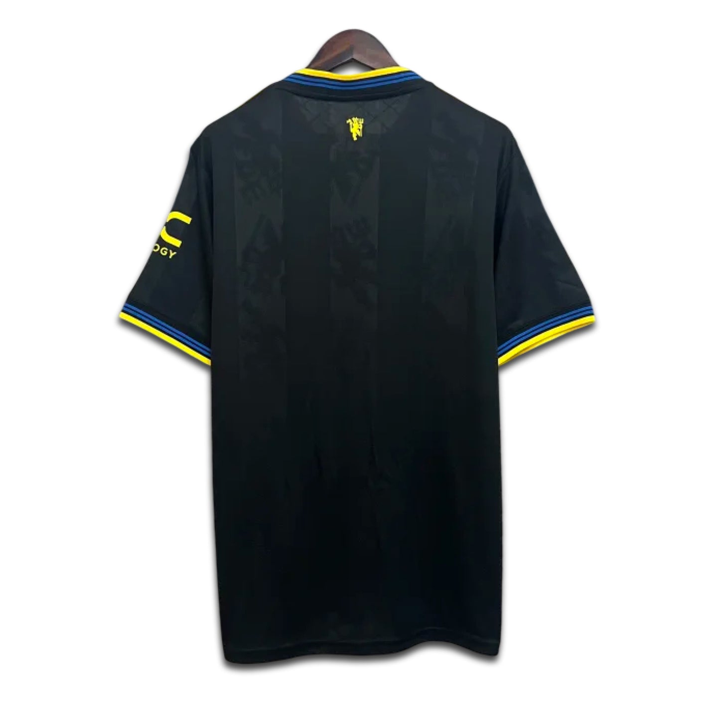 Black Manchester United shirt with yellow accents on a hanger against a white background