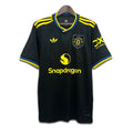 Black Manchester United jersey with yellow accents and brand logos on a white background