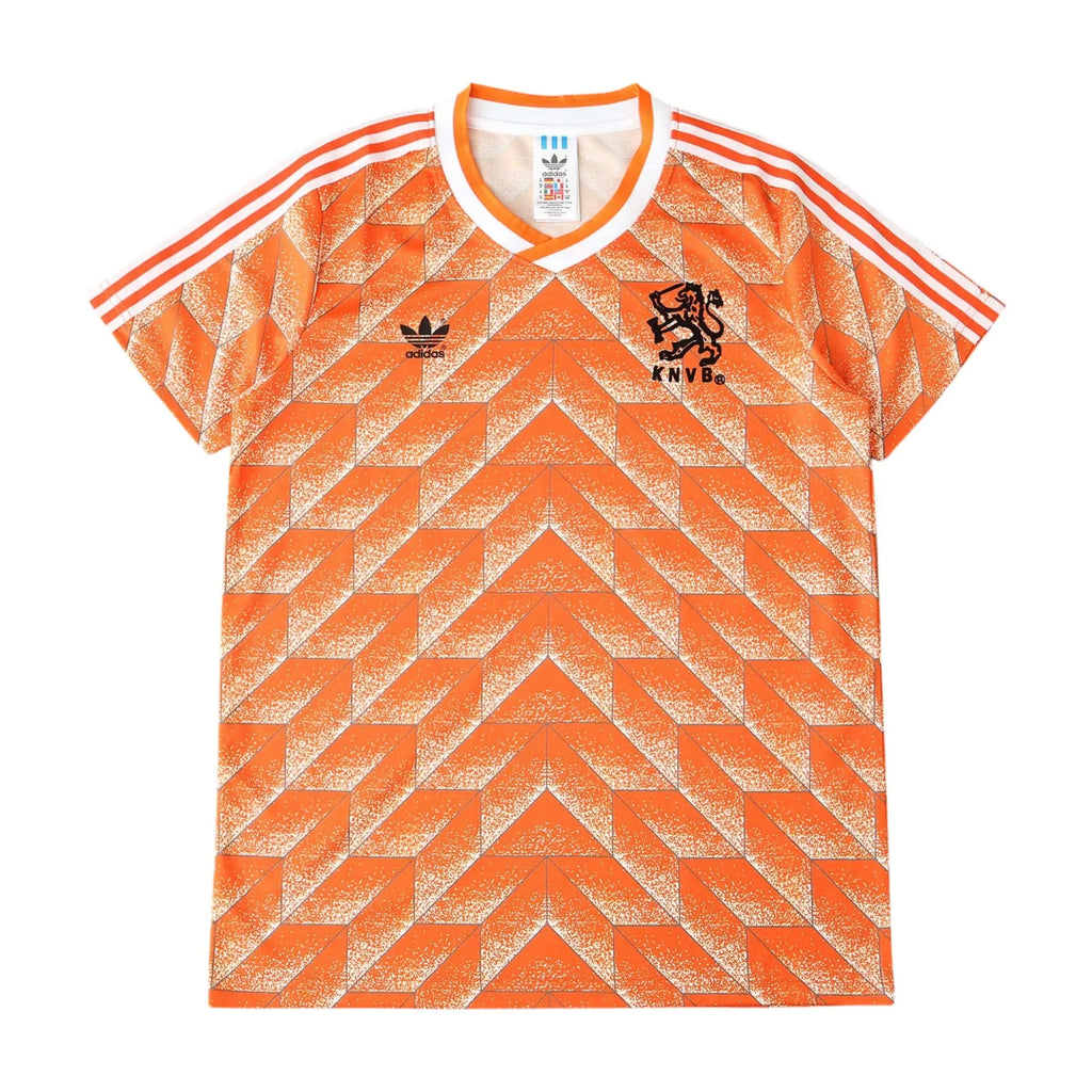 Orange and white Adidas Netherlands soccer jersey with a geometric pattern, featuring the Adidas logo and the lion crest with 'NEDERLAND' on the chest.