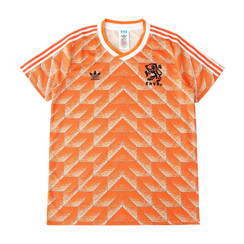 Orange and white Adidas Netherlands soccer jersey with a geometric pattern, featuring the Adidas logo and the lion crest with 'NEDERLAND' on the chest.