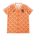 Orange and white Adidas Netherlands soccer jersey with a geometric pattern, featuring the Adidas logo and the lion crest with 'NEDERLAND' on the chest.