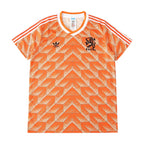 Orange and white Adidas Netherlands soccer jersey with a geometric pattern, featuring the Adidas logo and the lion crest with 'NEDERLAND' on the chest.