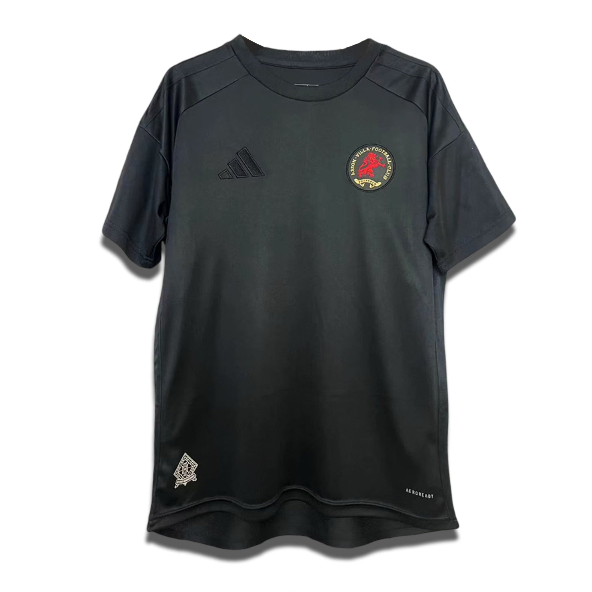 A black Aston Villa shirt with a crest and logo on the front, along with a small badge on the lower right. It features short sleeves and a round neckline.