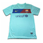 A blue short-sleeved soccer jersey with a red and white bar on the chest, featuring the Barcelona FC crest and the UNICEF logo, with a Nike logo at the top.
