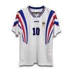 A white football jersey with blue and red accents and the number 10 visible on the front.