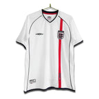 A white England national football team home shirt with a central red stripe and the England crest on the chest, displayed on a hanger.