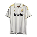 A white Real Madrid home shirt from the 2011/12 season with subtle gold trim and the Bwin sponsor logo.