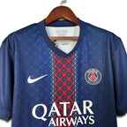 Blue Paris Saint Germain jersey with red and white pattern and 'Qatar Airways' branding on a hanger.