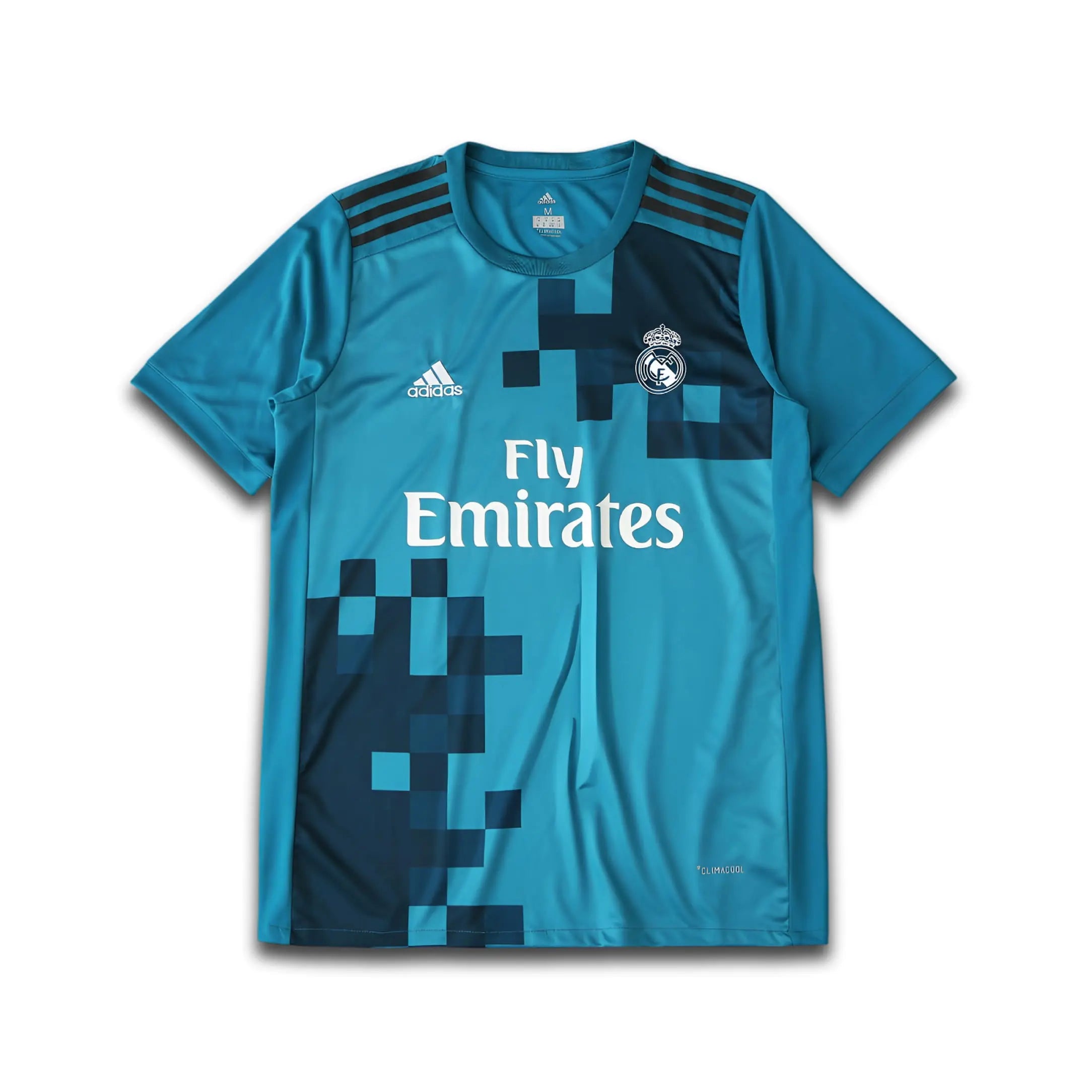 Blue Geometric Real Madrid shirt on a white background with Fly Emirates sponsor.