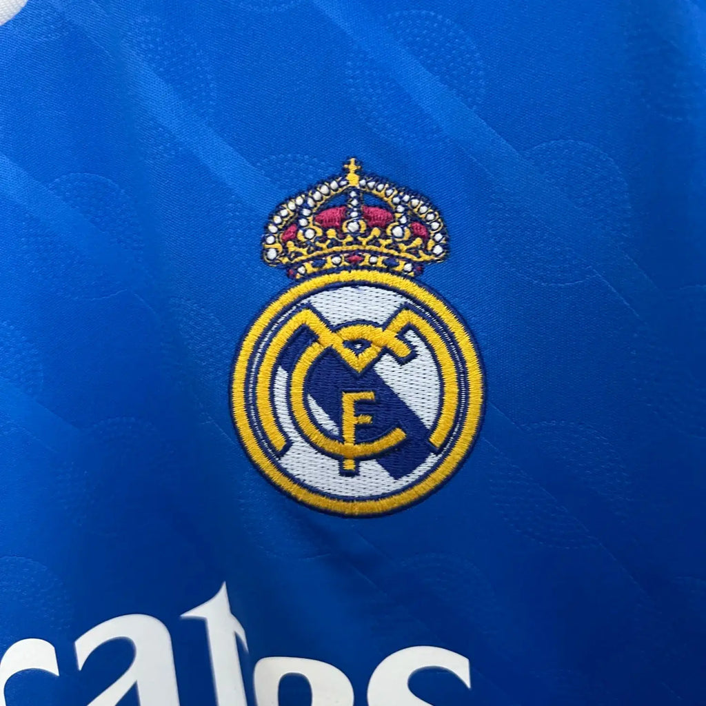 Close-up of Real Madrid logo on a blue sports jersey