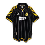 A black and yellow Real Madrid away retro jersey from the 1999/2000 season with the Teka sponsor logo, Adidas branding, and the Real Madrid crest.