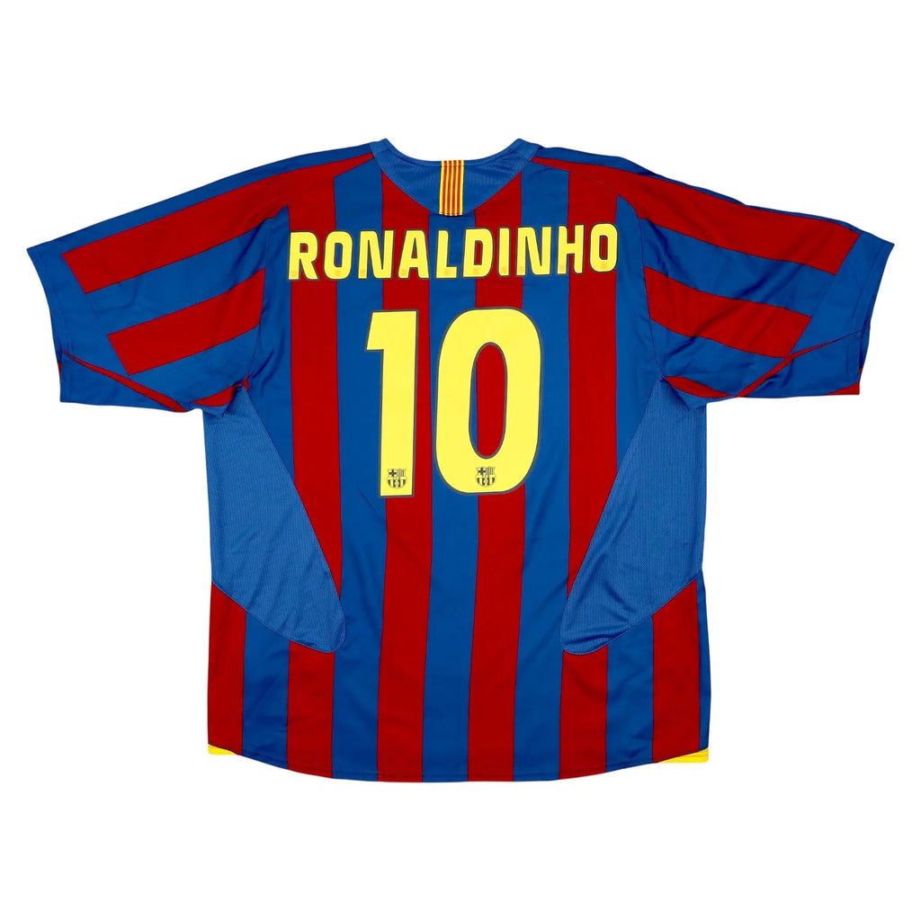 Back view of a FC Barcelona Ronaldinho number 10 soccer jersey with blue and red vertical stripes, yellow lettering, and a white background.